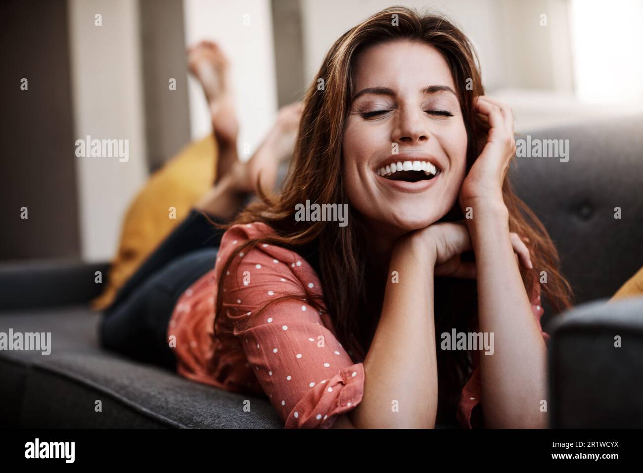 Rallenta e pianifica un po' di tempo. una giovane donna attraente che si rilassa sul divano a casa. Foto Stock