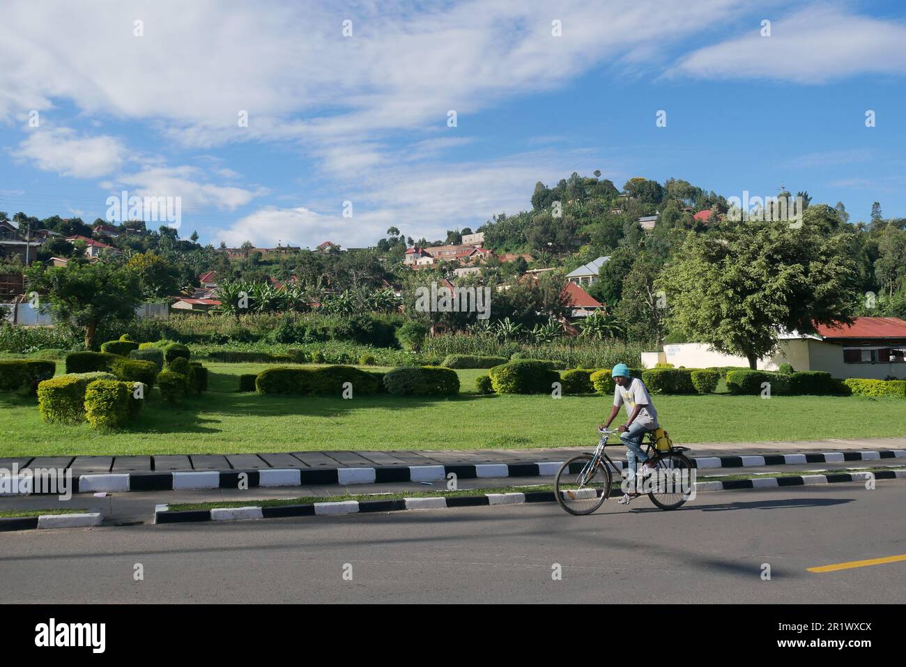 Uomo ruandese in bicicletta su strade vuote durante la pandemia di coronavirus Foto Stock