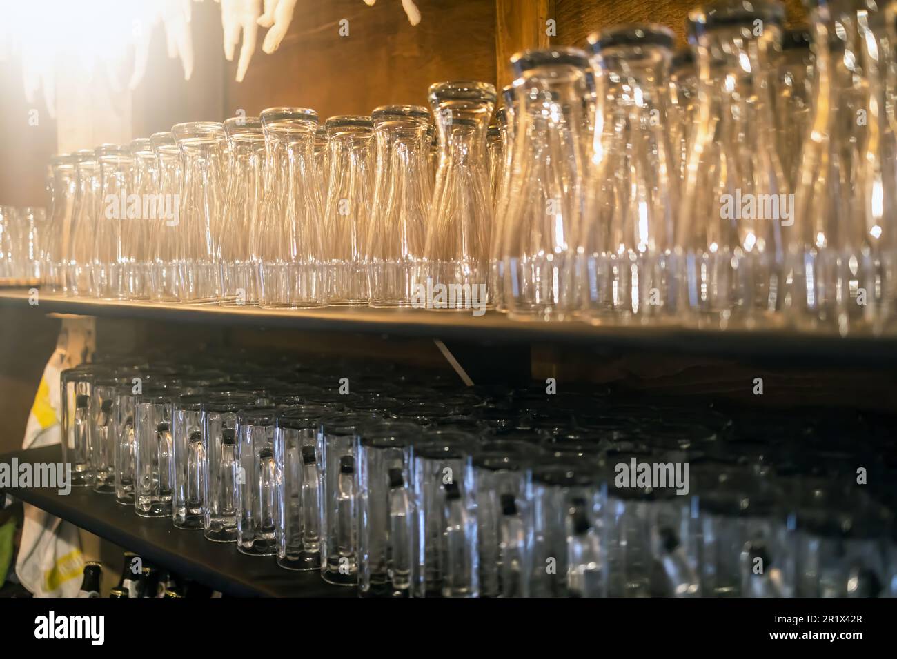 Bicchieri da bibita in fila su uno scaffale della gastronomia Foto Stock