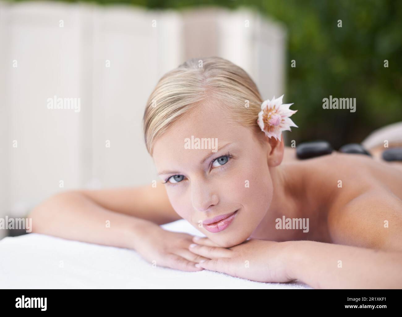 Tutto naturale. Una giovane donna che guarda la macchina fotografica mentre sdraiata su un tavolo da massaggio. Foto Stock