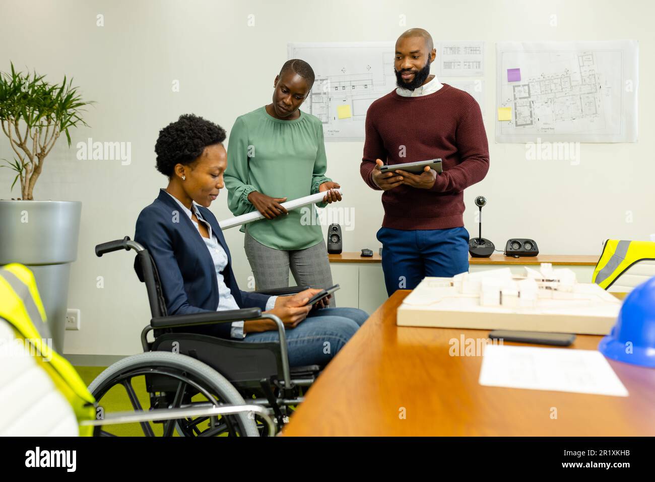 Colleghi afro-americani che discutono di un nuovo progetto su BluePrint e tablet digitali in ufficio Foto Stock