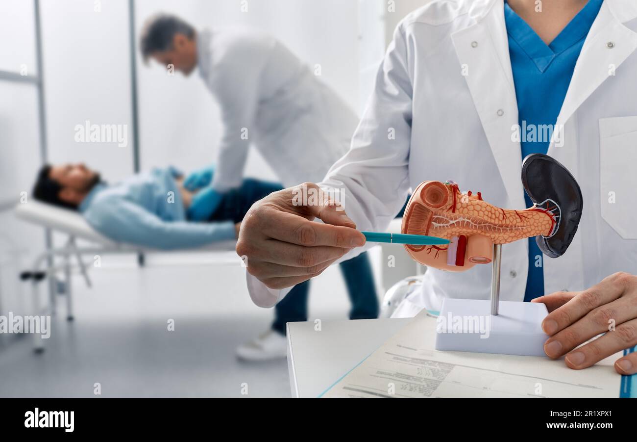 il medico palpa l'uomo paziente addome e esamina la pancia in clinica medica per analizzare lo stato del pancreas. Trattamento di malattie pancreatiche, acute e. Foto Stock