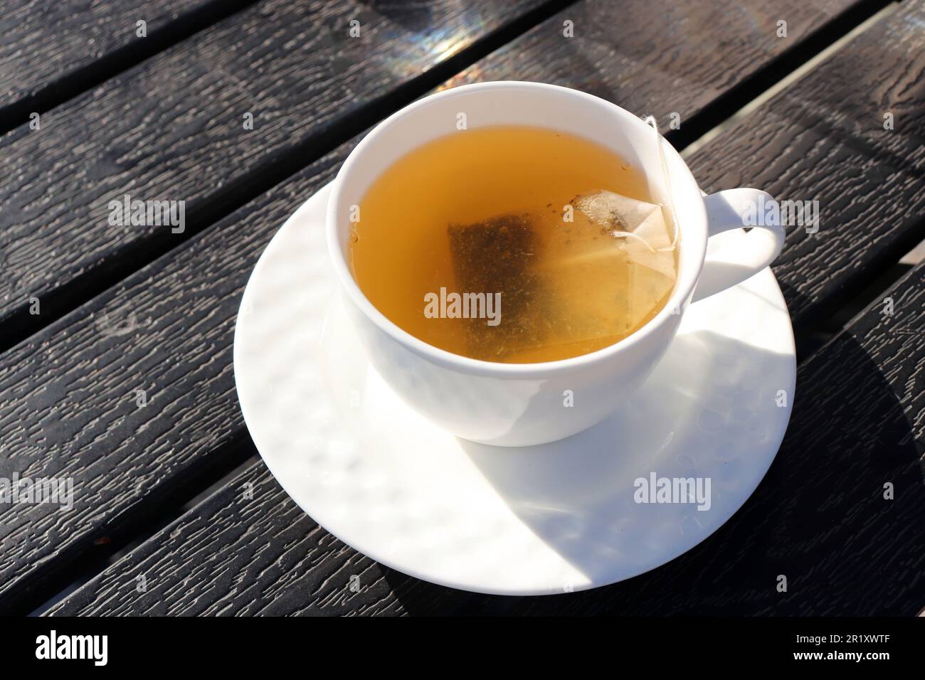 Una tazza di tè verde su sfondo di legno nero. La pulizia o il tè di detox è una buona opzione per la perdita del peso. Proprietà antiossidanti. Spazio di copia. sano Foto Stock