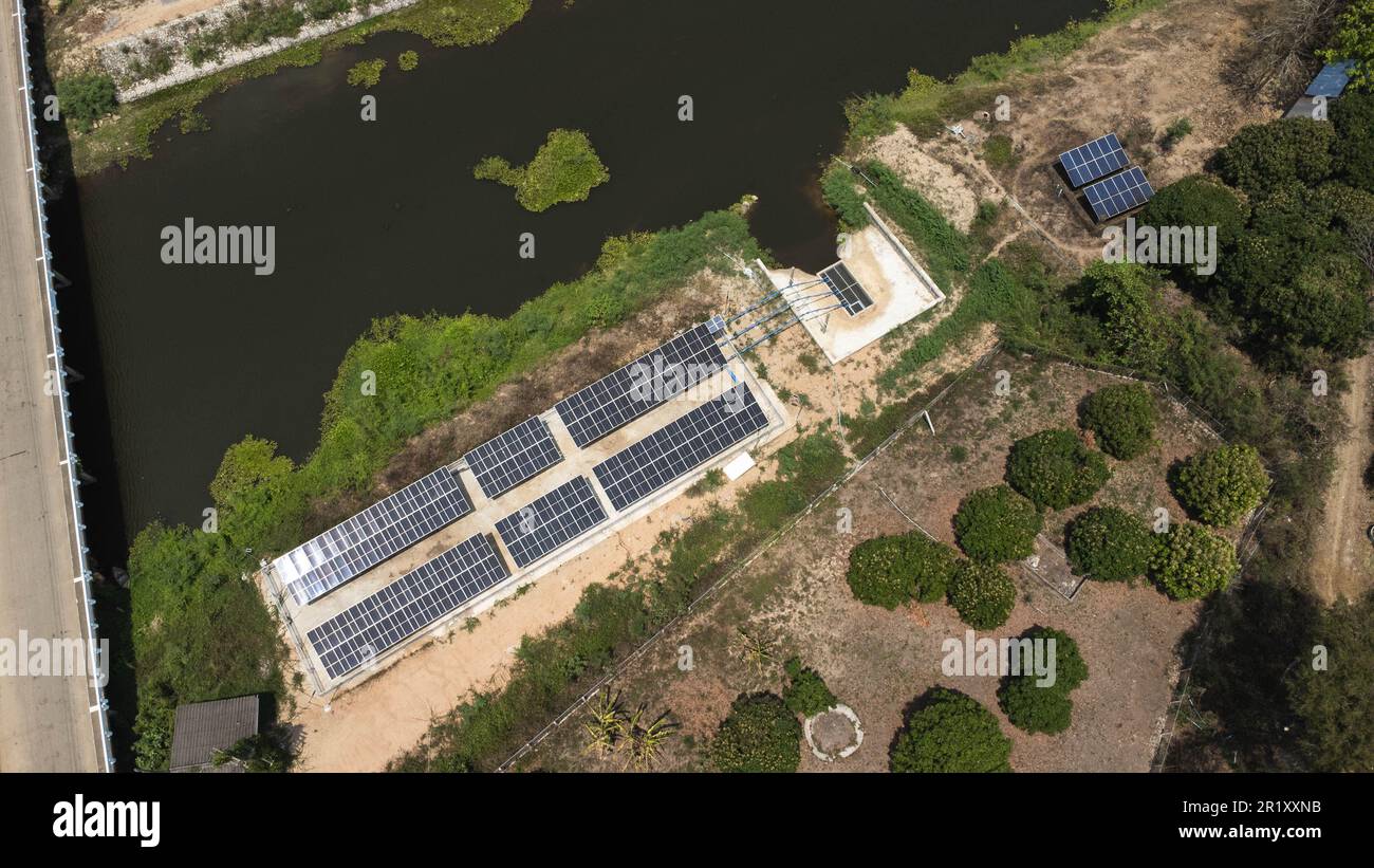 Vista dall'alto sui pannelli fotovoltaici a energia solare. Vista aerea drone di pannelli solari con pompe d'acqua, attrezzature agricole per l'irrigazione nei pressi di fiumi Fro Foto Stock