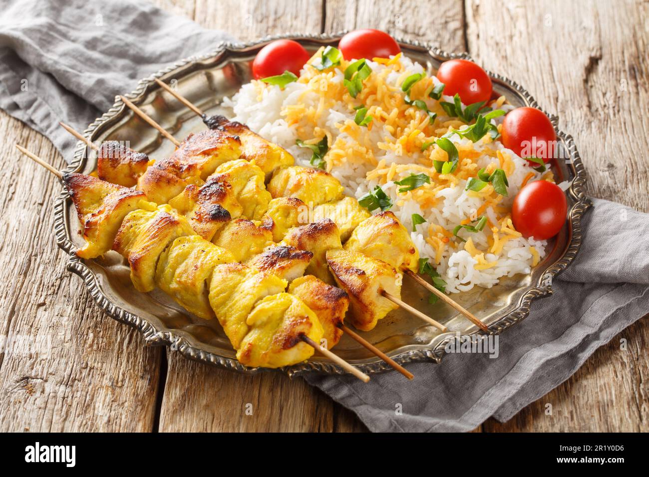 Joojeh Kabab è un delizioso piatto di pollo persiano dal sapore unico allo zafferano servito con un primo piano di riso sul piatto. Orizzontale Foto Stock