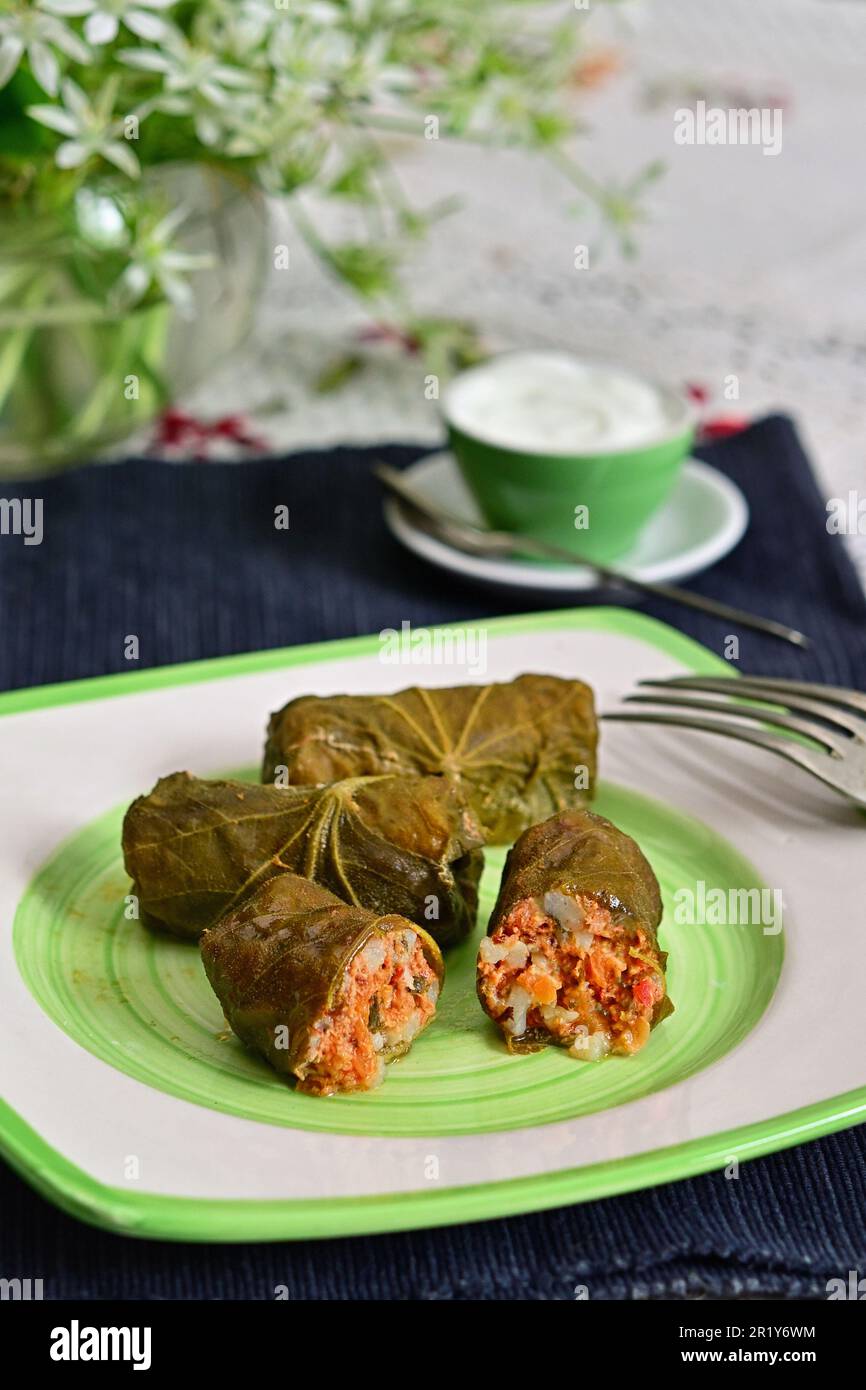 Dolma Rolls ripieni di carne, riso e verdure arrotolati in foglie di Lindens con Crema Foto Stock
