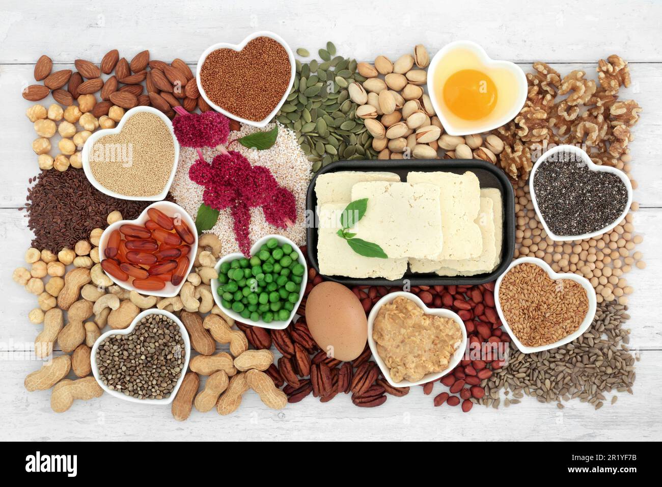 Cibo sano vegetariano cuore alto in lipidi acidi grassi essenital contenenti grassi insaturi buoni per bassi livelli di colesterolo con noci, semi, latticini Foto Stock
