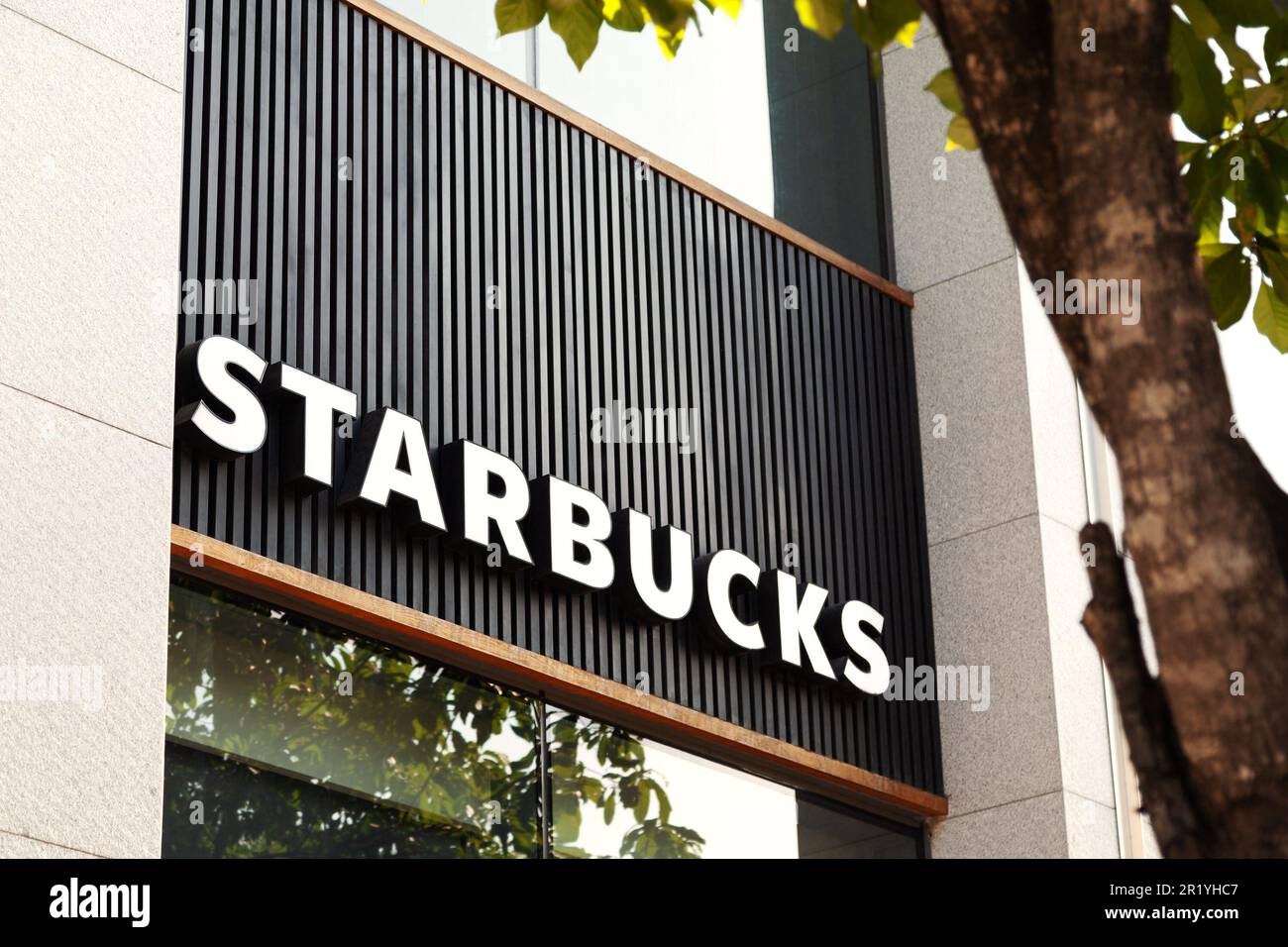 Ho Chi Minh City, Vietnam - 7 aprile 2023: Cartello commerciale su una famosa caffetteria con il logo Starbucks. Popolare pubblicità del marchio della caffetteria su un b Foto Stock