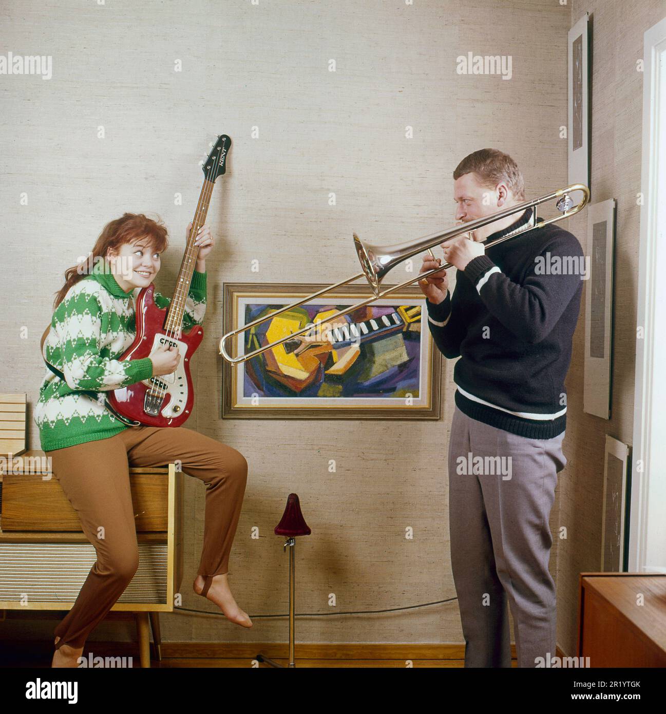 Negli anni '1960s. Una coppia si vede suonare il trombone e una chitarra elettrica, che appare felice e giocosa. Svezia 1963. Conard Foto Stock