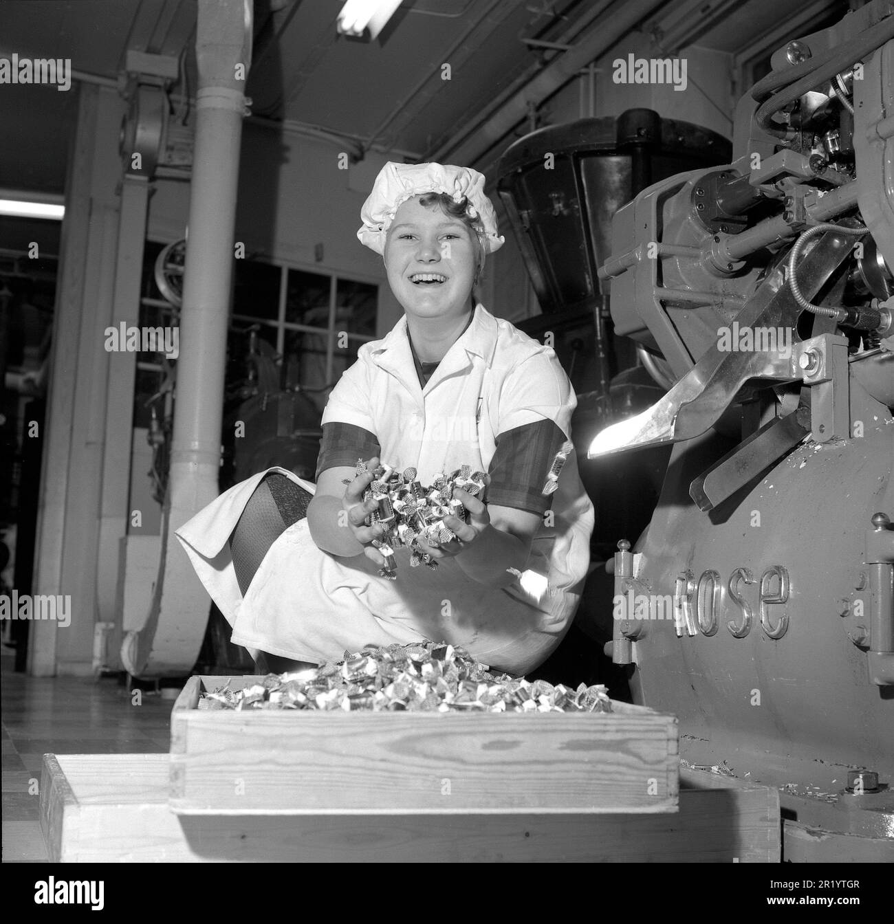 Fabbrica di caramelle negli anni '1960s. Una donna ad Ahlgrens in Gävle che tiene la loro caramella popolare del caramello avvolta in carta appena fatta alla fabbrica. Svezia 1962. Rif. Conard 4555 Foto Stock