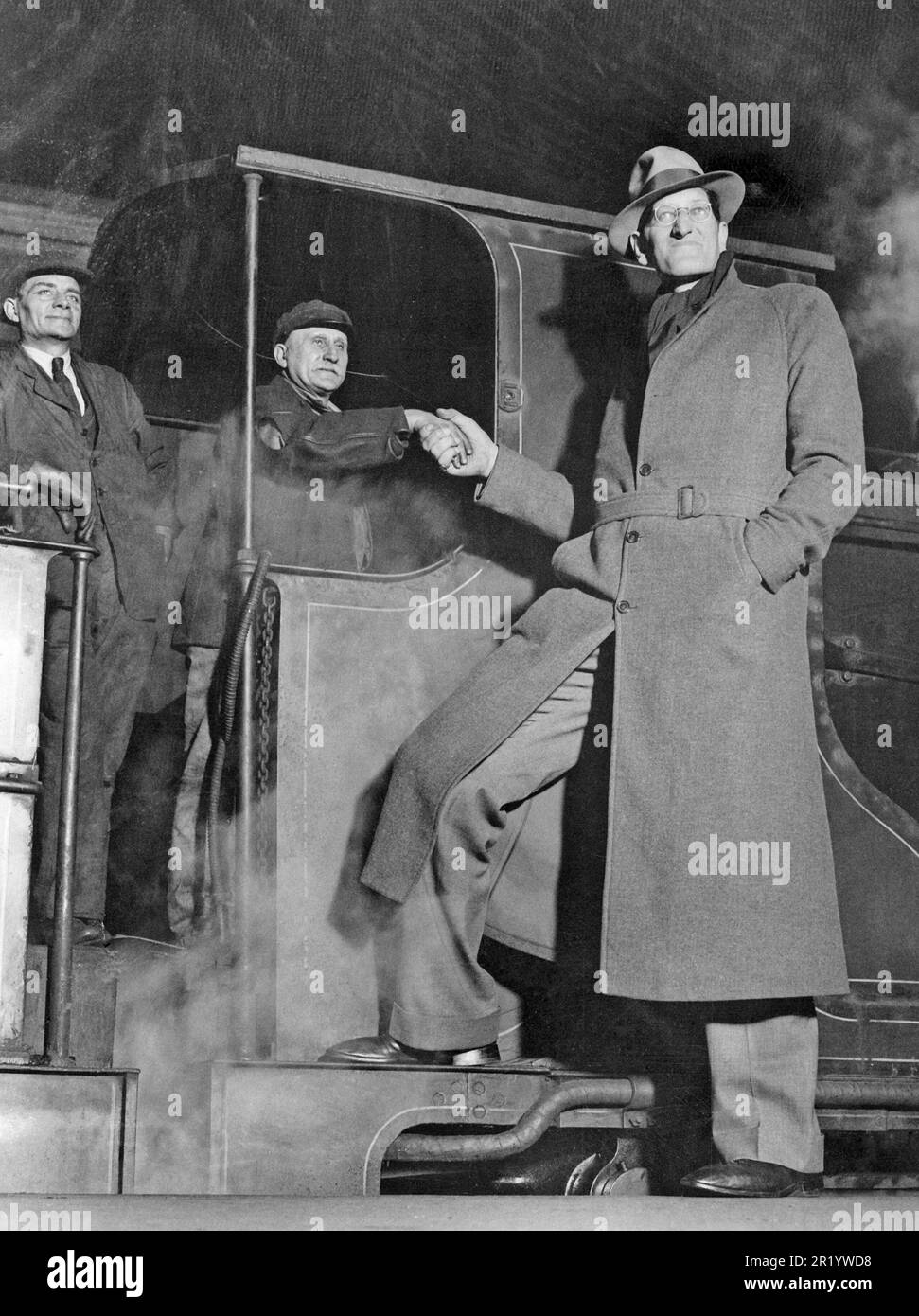 L'uomo più alto del mondo. Jacob Rheuben Erlich, professionalmente accreditato come Jack Earle alto 244 cm saluta l'ingegnere del treno alla stazione di Waterloo a Londra Inghilterra. È nato a Dever Colorado USA il 28 giugno 1906. È stato una star del cinema nei primi film silenziosi del 50 e ha trascorso 14 anni in tournée con la leggendaria compagnia 'Ringling Brothers, Barnum & Bailey' come artista circense 'Pecos Bill'. Dopo la sua carriera nel circo, divenne venditore della Roma Wine Company. È stato fatturato come 'il venditore di viaggio più alto del mondo'. Inoltre, Earle era un artista di talento e ha lavorato in una varietà di media, tra cui Foto Stock