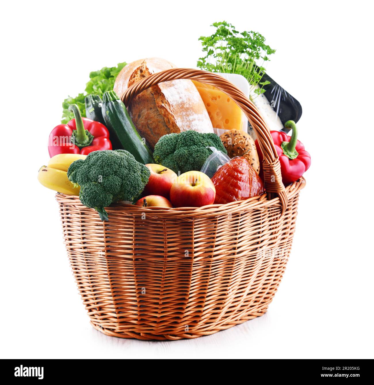 Cesto di vimini con prodotti alimentari assortiti isolati su sfondo bianco Foto Stock
