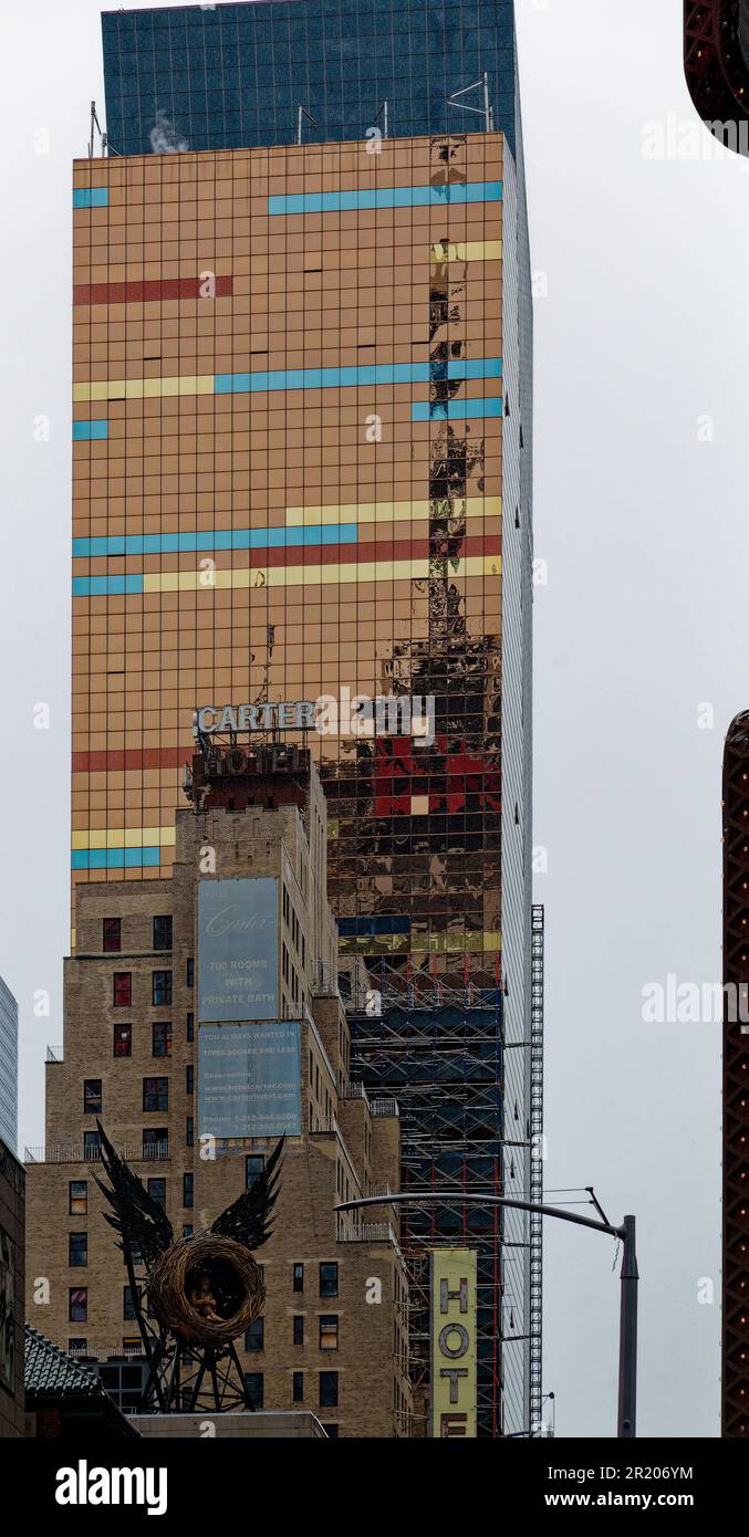 Un luminoso tocco di colore anche sotto la pioggia, l'hotel Westin New York, rivestito in vetro, e' lo sfondo del carter Hotel in mattoni a staid sulla West 42nd Street. Foto Stock