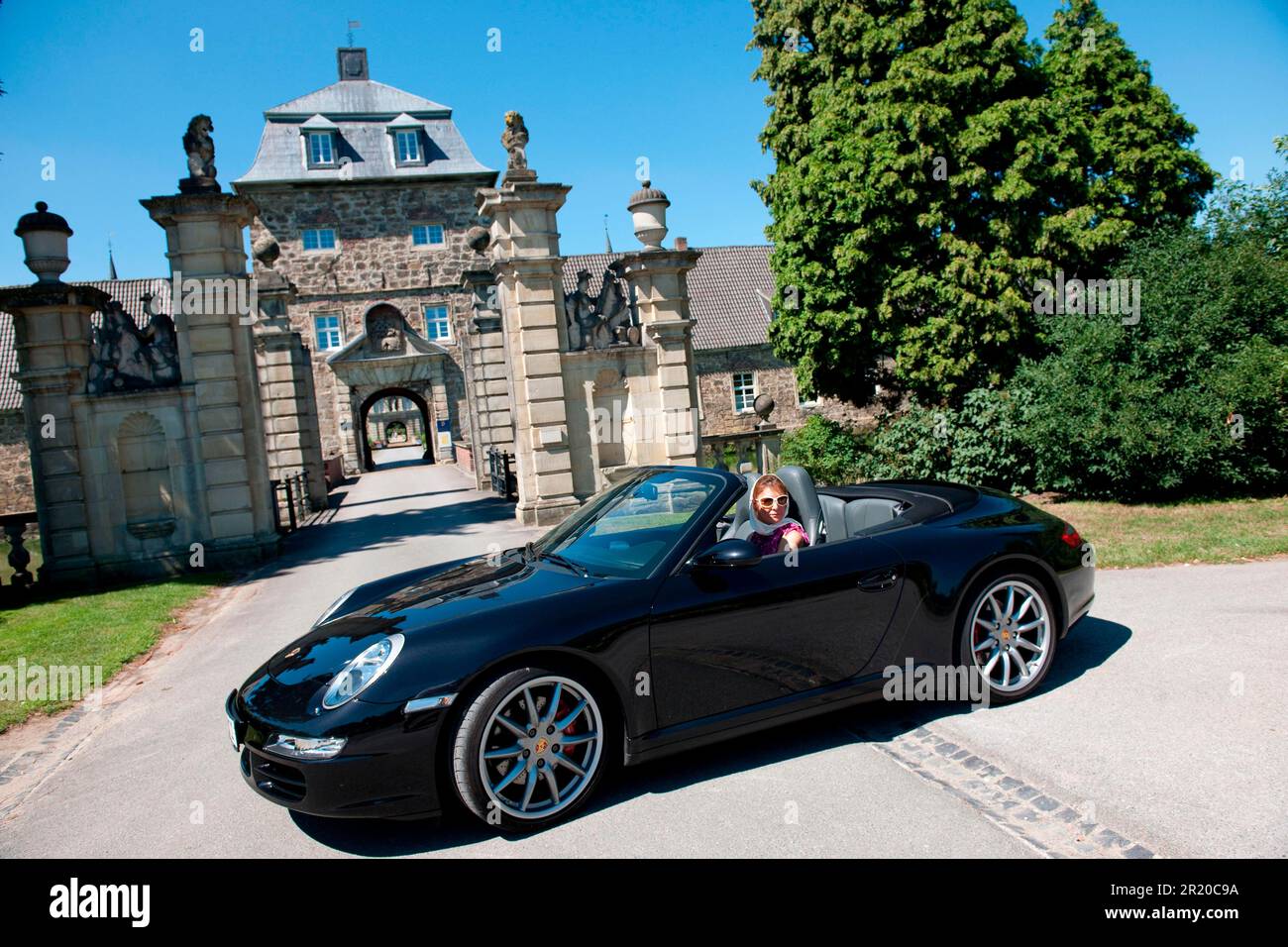 Donna con Porsche 911 cabriolet di fronte al castello, Porsche Carrera 4S Cabriolet, convertibile, auto sportiva Foto Stock