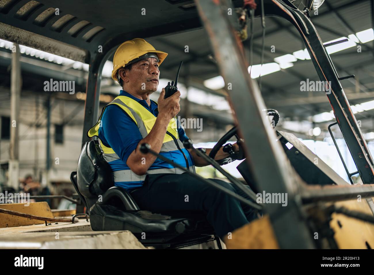 L'operatore di Folklift guida il Folklift per trasferire, consegnare e trasferire la merce su scaffali e pallet. Mantenersi aggiornati sulle procedure operative con il collega Foto Stock