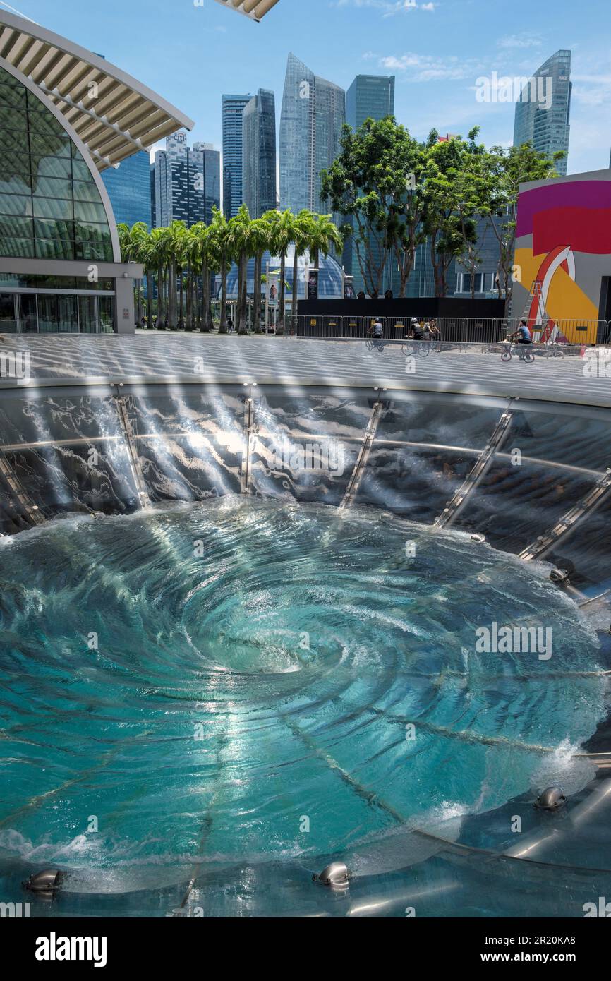 Una caratteristica d'acqua con idromassaggio a Marina Bay che guarda al quartiere finanziario di Singapore Foto Stock