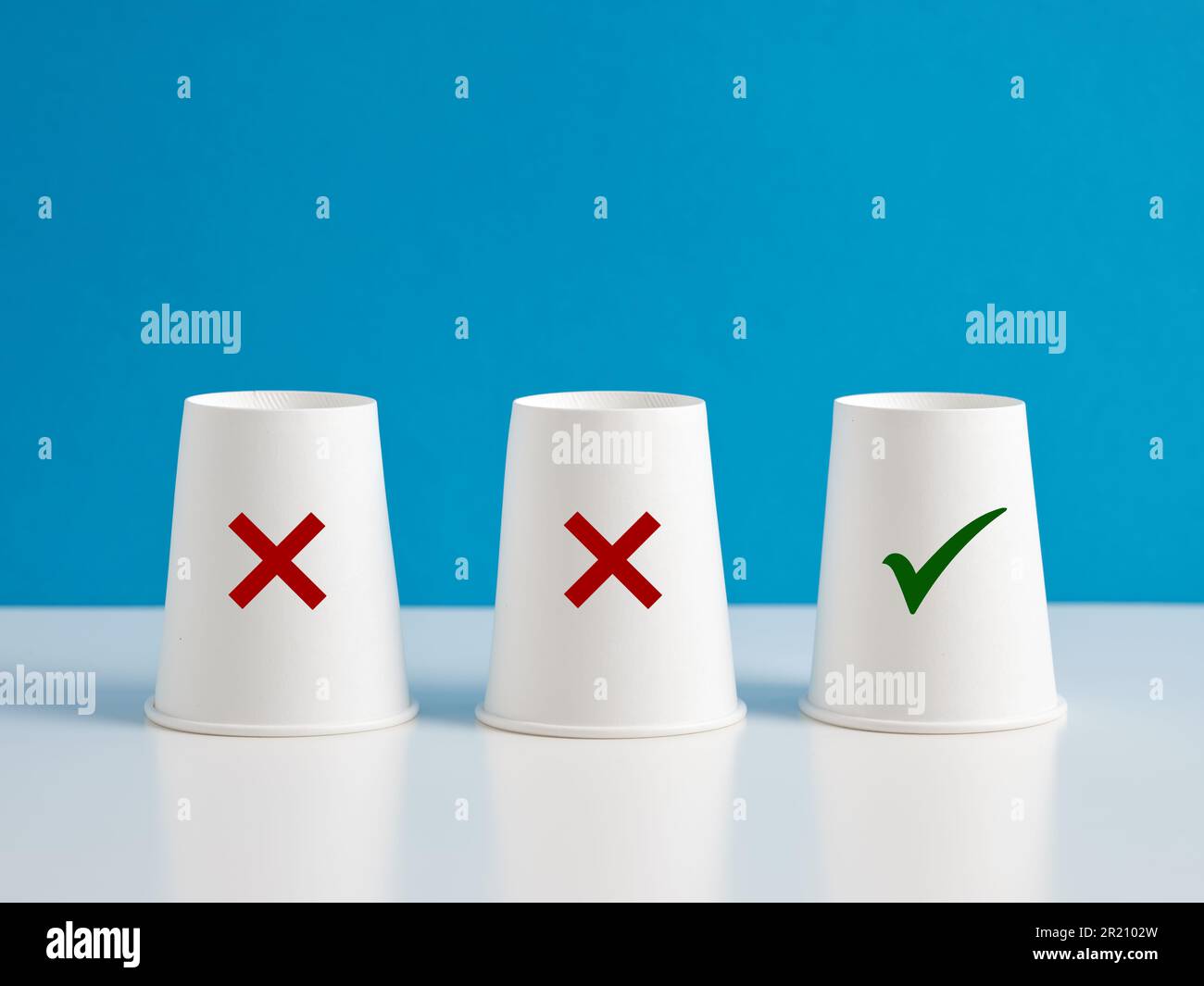 Sbagliato o giusto. Prendere la decisione giusta o scegliere l'opzione giusta. Tre bicchieri di carta con icone di segno di spunta e croce x su sfondo blu. Foto Stock