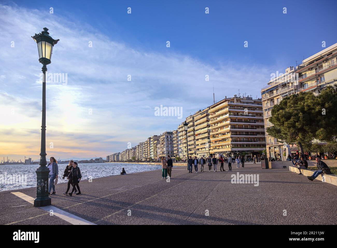 Salonicco, Grecia, 28 aprile 2023: Passeggiata pedonale sulla riva del molo del Mar Mediterraneo al sole serale, meta popolare per il tour Foto Stock