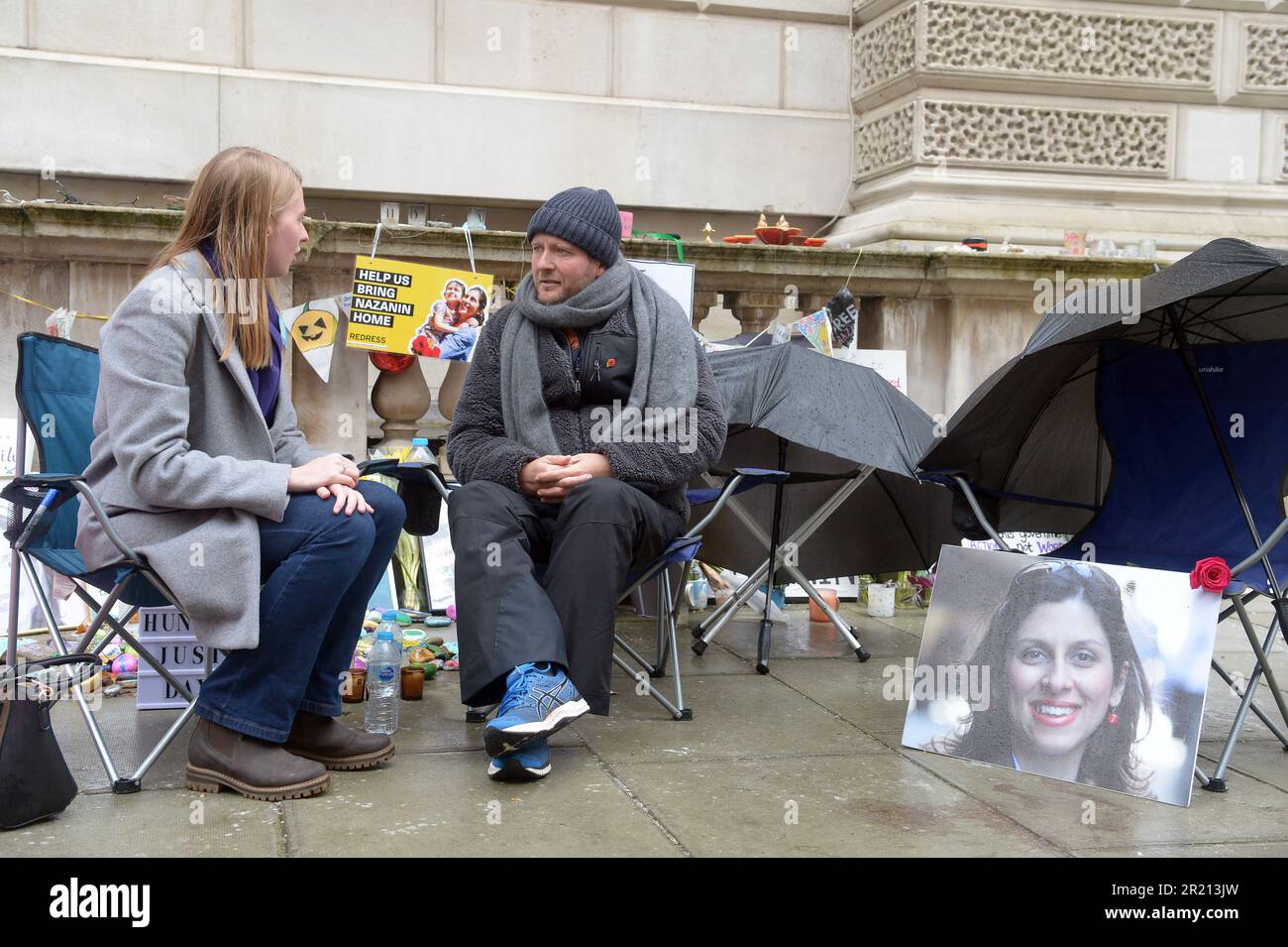 Un membro del pubblico si siede e chiacchiera con Richard Ratcliffe mentre protesta al di fuori del Foreign Office di Londra nel suo continuo sforzo di esortare il governo britannico a fare pressioni sull'Iran per liberare sua moglie Nazanin Zaghari-Ratcliffe, un doppio cittadino iraniano-britannico, Che è stato detenuto dalle autorità iraniane dal 2016. Le paure aumentarono riguardo al benessere di Richard Ratcliffe mentre il suo sciopero della fame entrò nel suo 18th° giorno. Novembre, 2021. Foto Stock