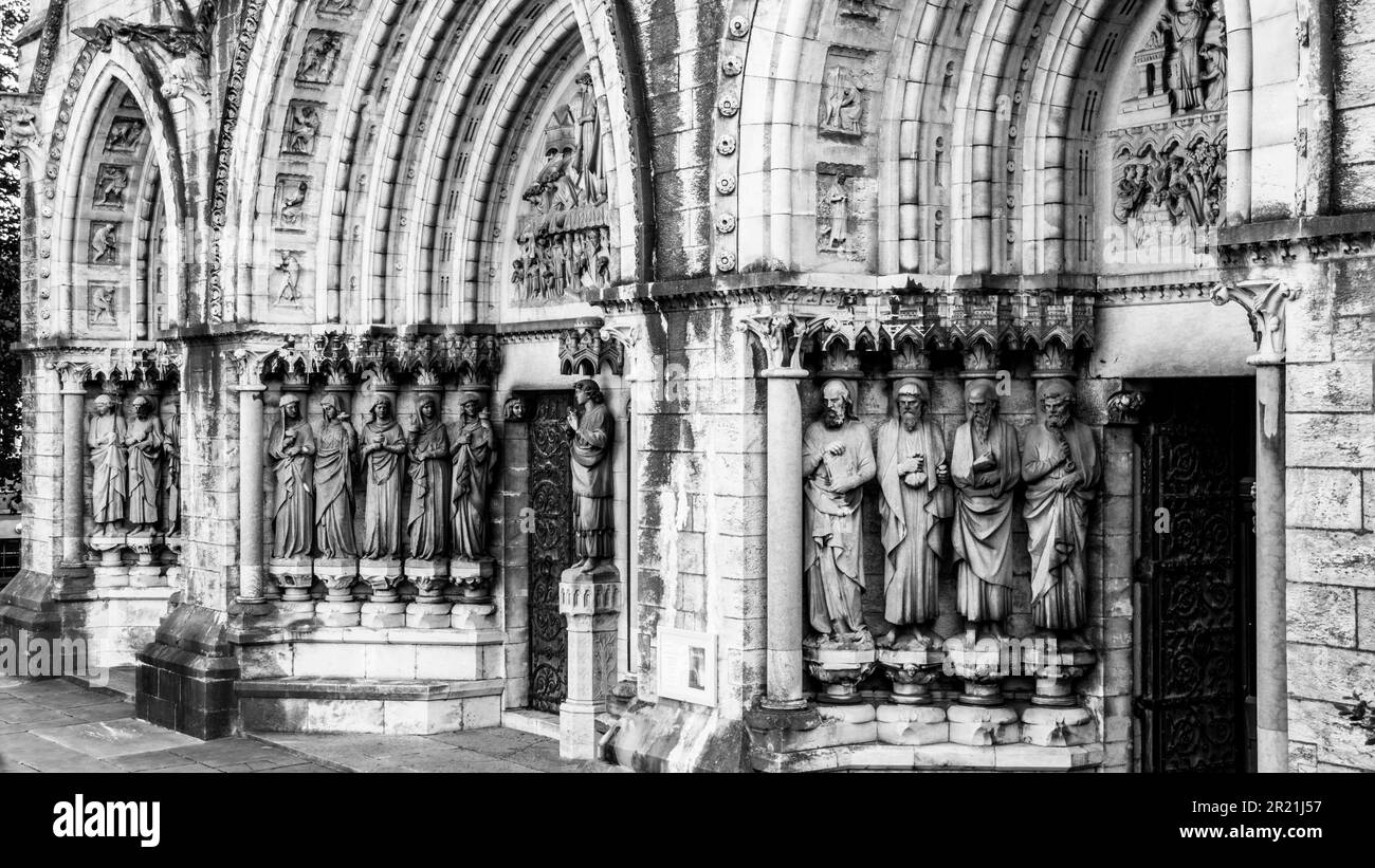 Dettagli della facciata della Cattedrale di Saint fin barre a Cork, Irlanda. Sculture di figure religiose all'ingresso della chiesa. monocromatico. Foto Stock