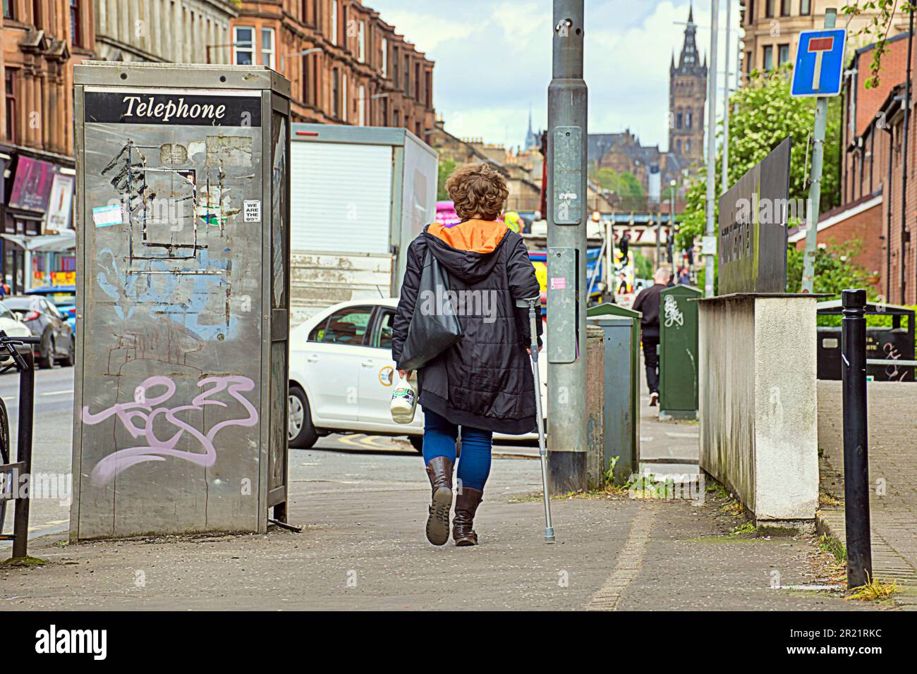 le donne di partick si godono il clima calmo e i loro affari in strada Foto Stock