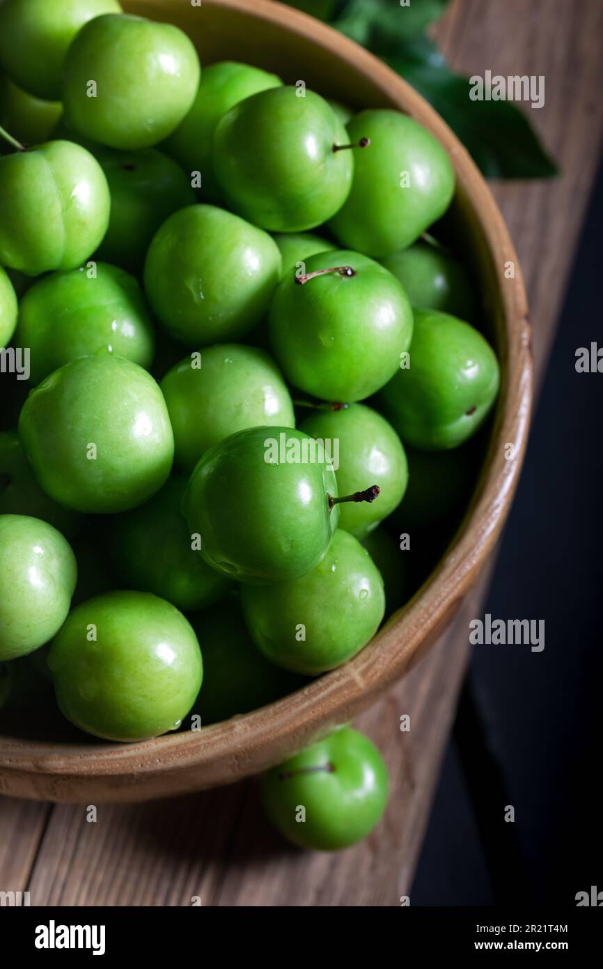 Prugne verdi fresche nel recipiente. Primo piano di prugne verdi fresche. Foto Stock