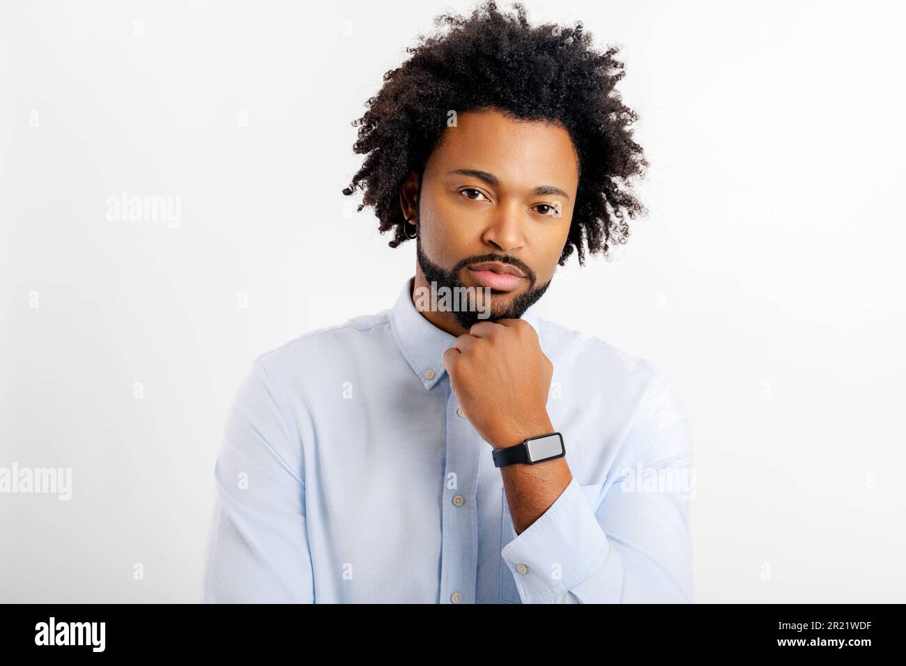 Un uomo nero pensante, che tiene il braccio vicino al mento, un uomo d'affari premuroso che risolve le attività, guardando la fotocamera isolata sul bianco Foto Stock