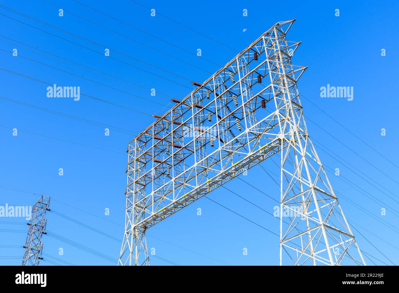 Grande pilone che supporta linee elettriche ad alta tensione in un chiaro giorno d'autunno Foto Stock