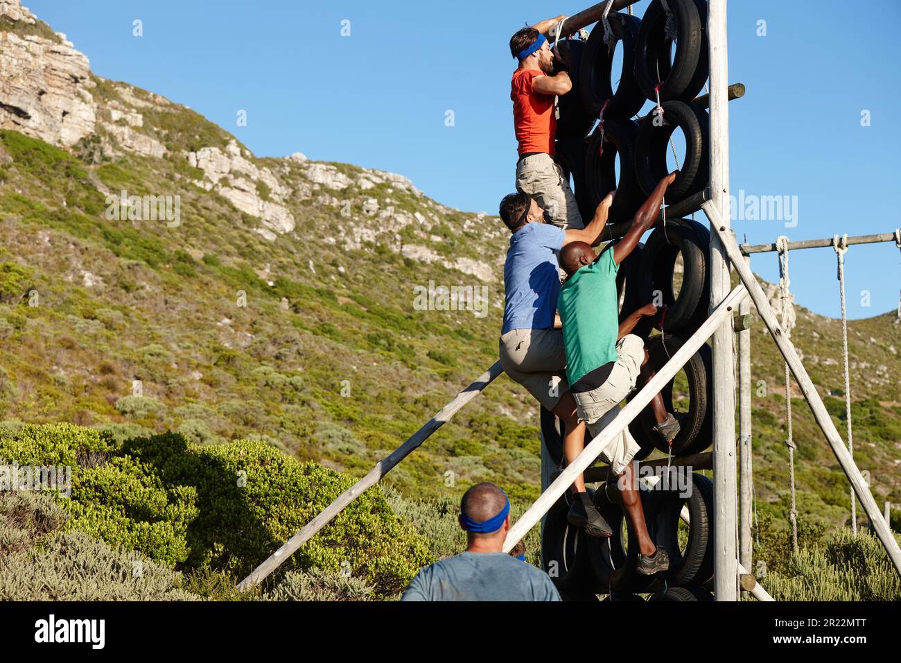 Superare ogni ostacolo messo nel vostro percorso. un gruppo di uomini che si arrampicano su un ostacolo in un bootcamp militare. Foto Stock