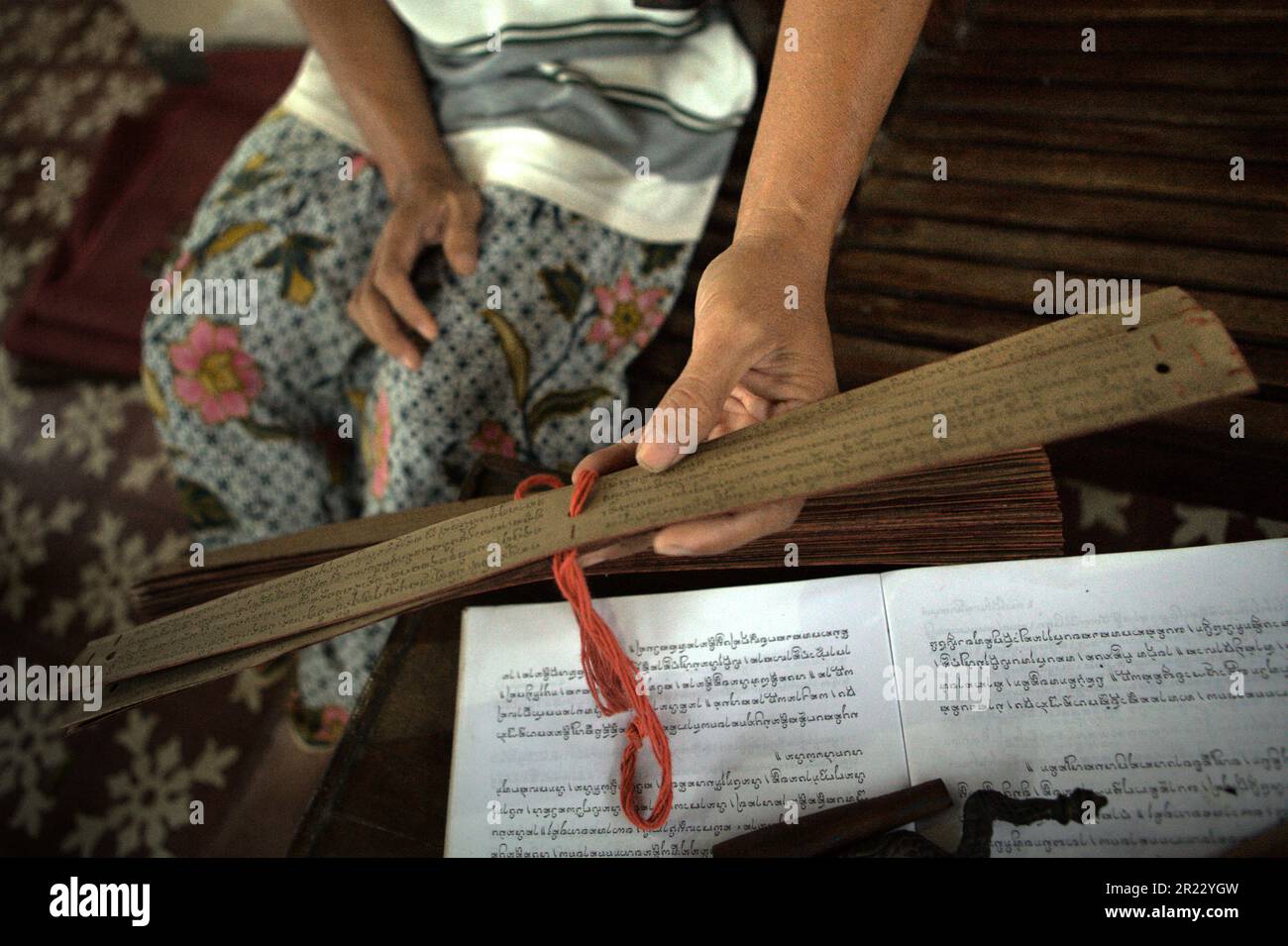 I Wayan Edi Wistara, un professionista del manoscritto balinese con foglie di palma, sta mostrando un insieme di fogli di palma, sui quali ha ricopiato vecchi testi balinesi nella sua casa a Karangasem, Bali, Indonesia. Alcuni praticanti stanno copiando vecchi testi balinesi su nuove foglie di palma per preservare la vecchia tradizione. Foto Stock