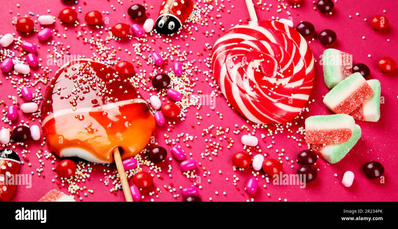 Collezione mista di caramelle colorate, su sfondo rosa. Vista dall'alto. Foto Stock