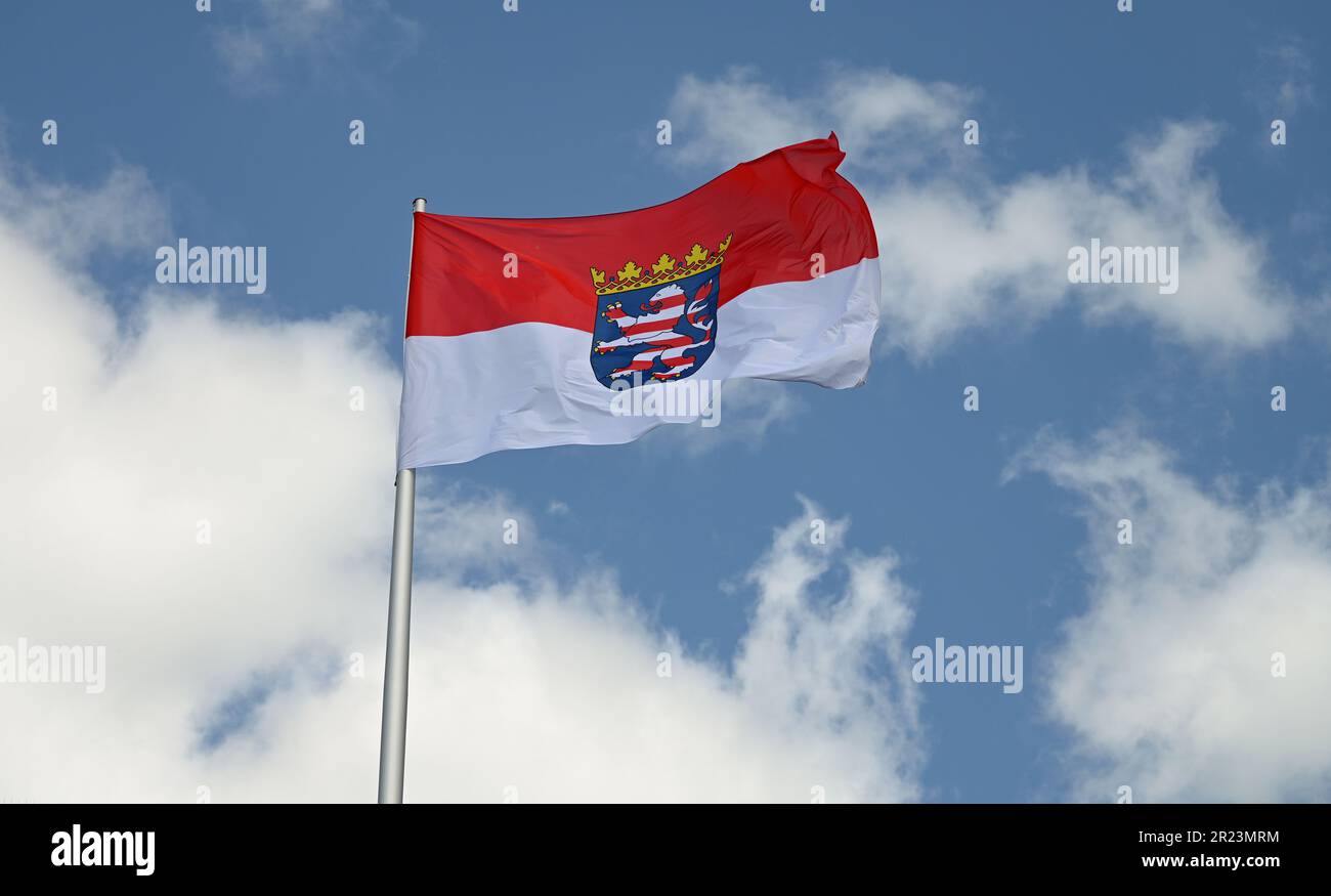 Wiesbaden, Germania. 16th maggio, 2023. La bandiera del servizio statale hessiano, la bandiera di stato rossa e bianca con lo stemma al centro, vola sul tetto del palazzo della città dove risiede il parlamento statale hessiano. I regolamenti in materia di segnalazione sono definiti con precisione nella legge del 1948 sugli emblemi nazionali dello Stato dell'Assia. Credit: Arne Dedert/dpa/Alamy Live News Foto Stock