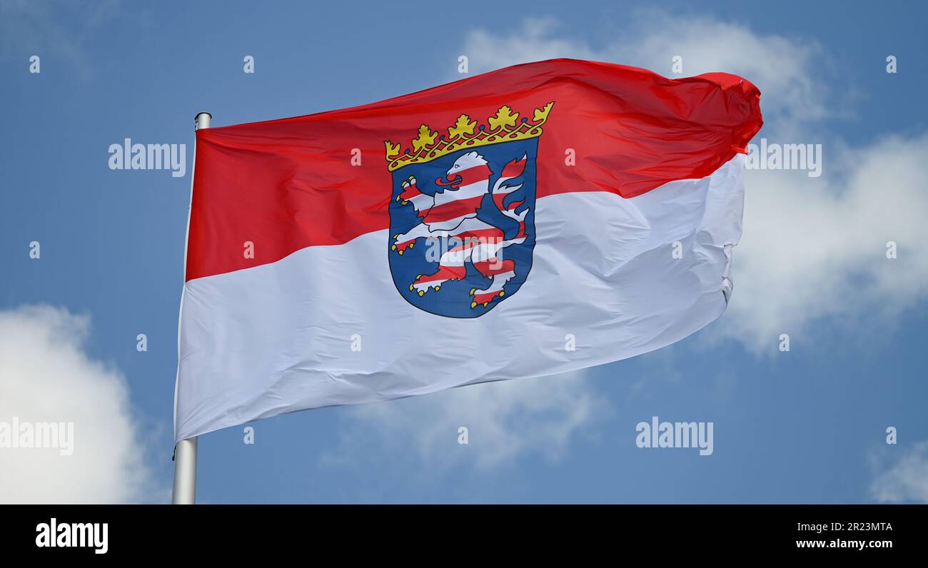 Wiesbaden, Germania. 16th maggio, 2023. La bandiera del servizio statale hessiano, la bandiera di stato rossa e bianca con lo stemma al centro, vola sul tetto del palazzo della città dove risiede il parlamento statale hessiano. I regolamenti in materia di segnalazione sono definiti con precisione nella legge del 1948 sugli emblemi nazionali dello Stato dell'Assia. Credit: Arne Dedert/dpa/Alamy Live News Foto Stock