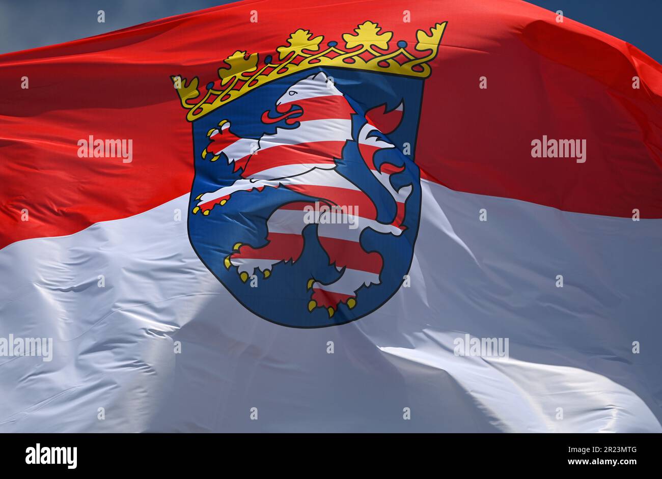 Wiesbaden, Germania. 16th maggio, 2023. La bandiera del servizio statale hessiano, la bandiera di stato rossa e bianca con lo stemma al centro, vola sul tetto del palazzo della città dove risiede il parlamento statale hessiano. I regolamenti in materia di segnalazione sono definiti con precisione nella legge del 1948 sugli emblemi nazionali dello Stato dell'Assia. Credit: Arne Dedert/dpa/Alamy Live News Foto Stock