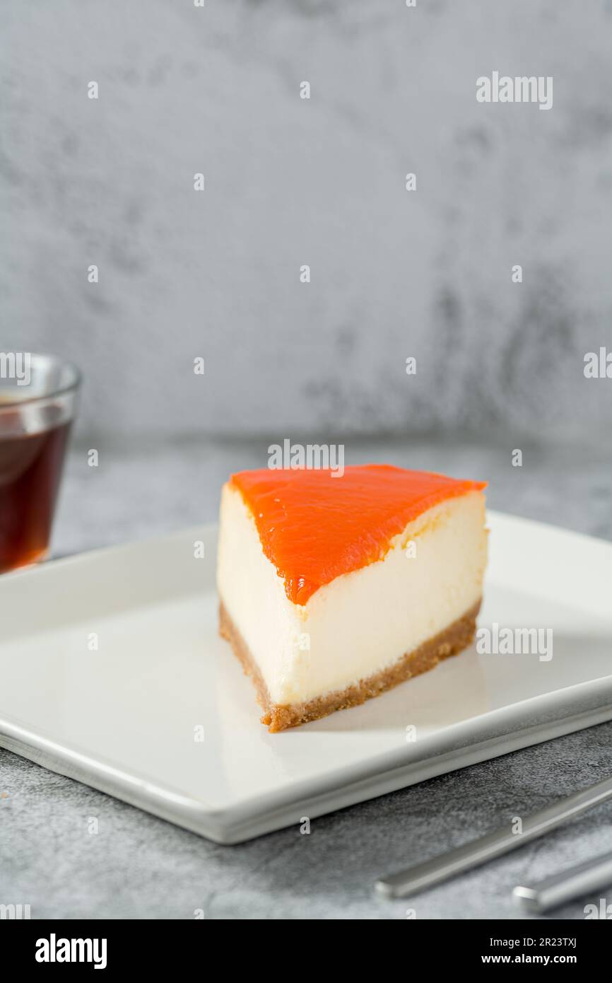 Cheesecake di zucca su piatto di porcellana con tè su tavolo di pietra Foto Stock