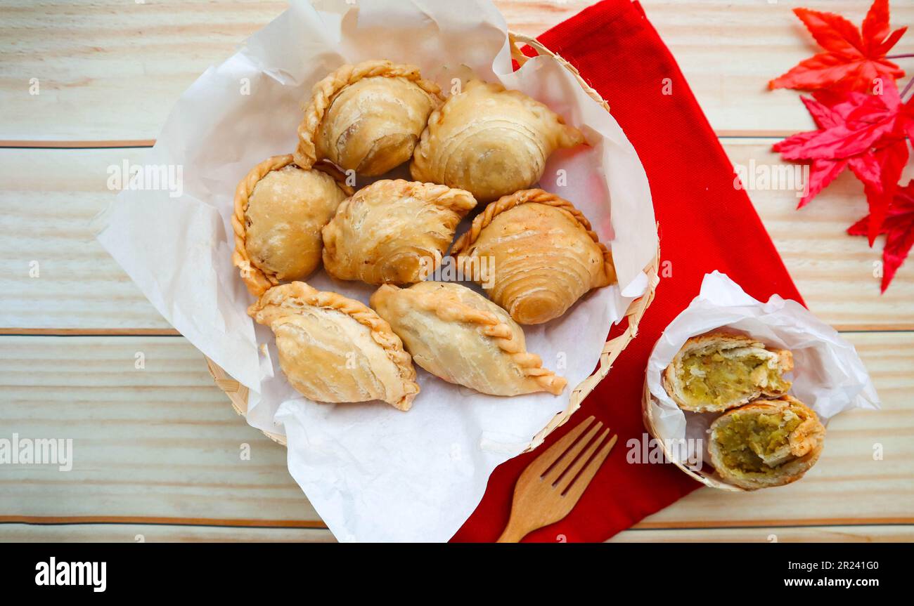 Ripieno di polli di curry fritti - ripieno di pollo e verdure, famoso malese chiamato epok-epok-epok in cima alla vista sul tavolo di legno Foto Stock