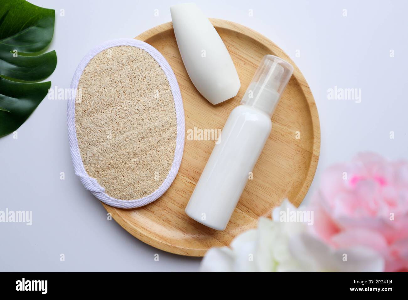 Posa piatta di prodotto per la cura del corpo, contiene di loofah, sapone e lozione per il corpo su sfondo bianco Foto Stock