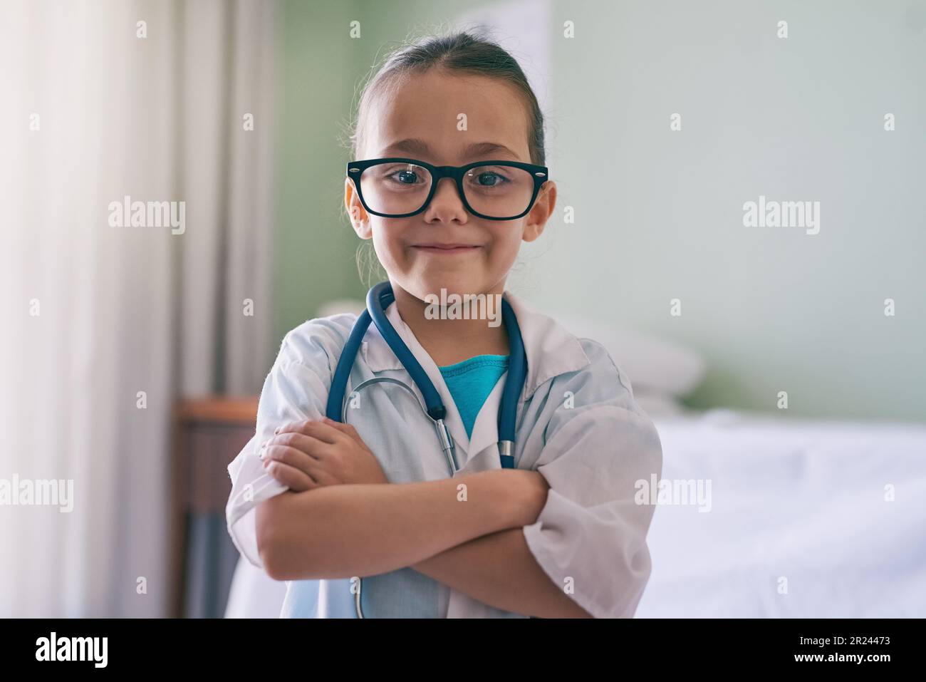 Bambina, ritratto e medico con sorriso, occhiali e stetoscopio in casa, ospedale o clinica. Femmina bambino, giocare medic e felice con eccitato Foto Stock