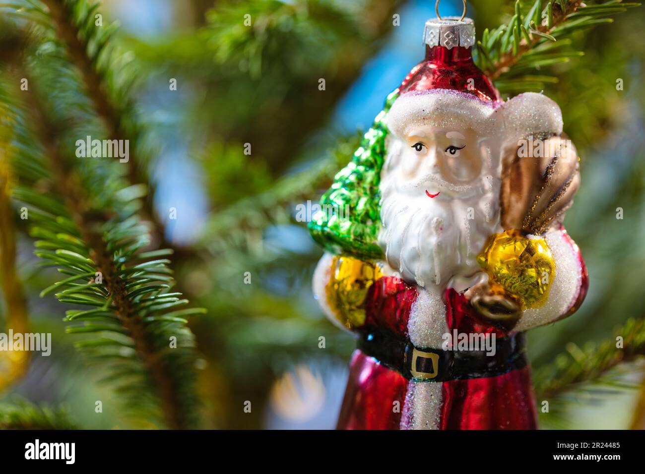 vetro babbo natale giocattolo su albero di natale naturale primo piano al coperto Foto Stock