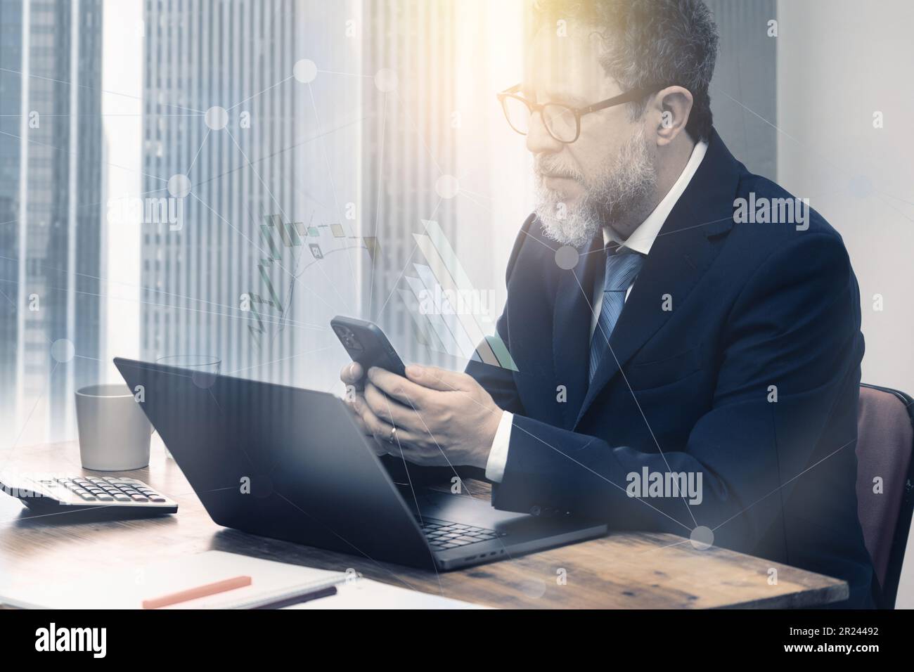 Una composizione grafica di un uomo maturo, circa 50 anni, seduto alla scrivania per controllare i dati finanziari su un telefono e un tablet, sovrapposta a grafici finanziari e. Foto Stock