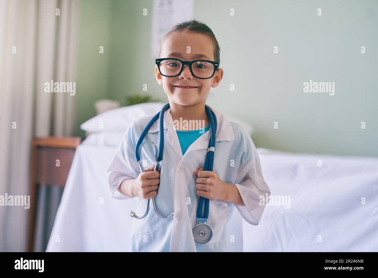 Bambina, ritratto e medico con sorriso, occhiali e stetoscopio in casa, ospedale o clinica. Femmina bambino, giocare medic e felice con Foto Stock