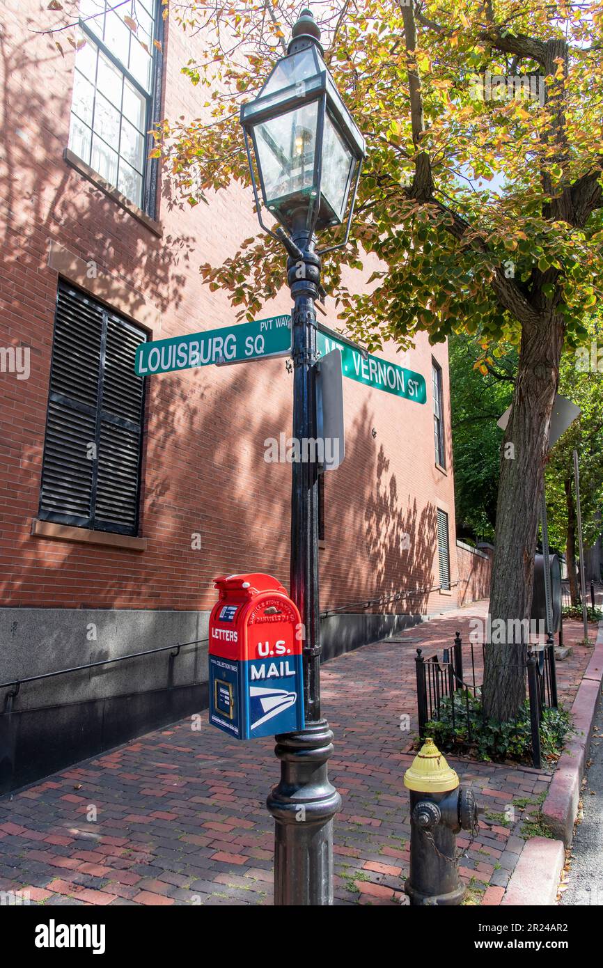Boston, ma, USA-Agosto 2022; Vista di un semaforo retrò con le indicazioni stradali allegate all'angolo tra Louisburg Square e Vernon Street Foto Stock