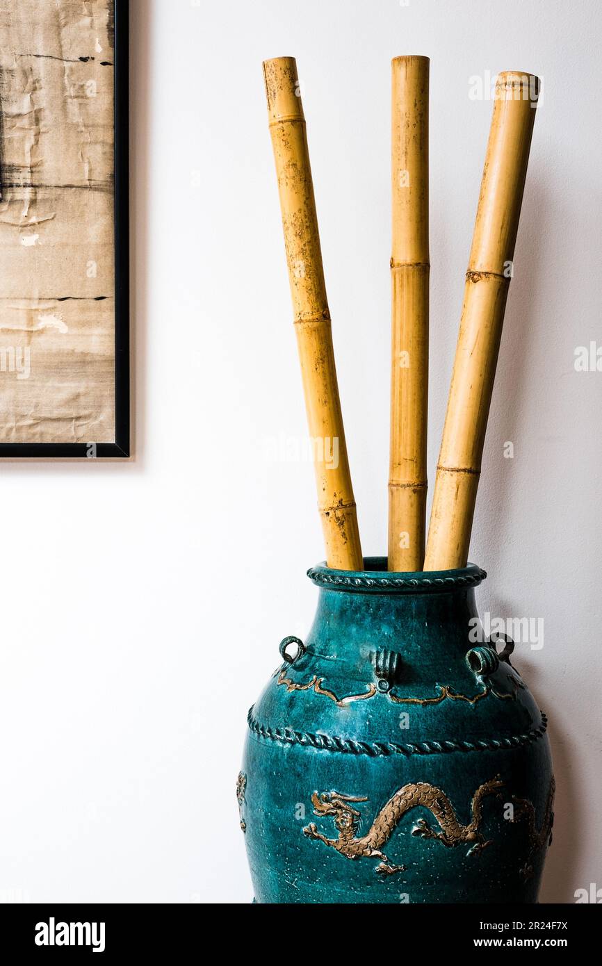Pali di bambù in un'urna cinese verde decorata con draghi. Foto Stock