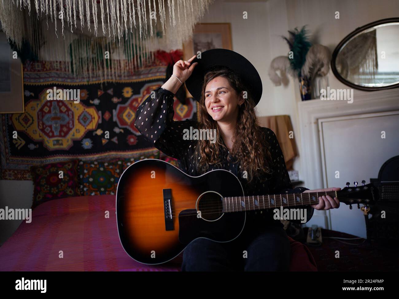 Joanna Roche, membro dello staff della Handel Hendrix House, posa con una chitarra in una ricostruzione dell'appartamento di Jimi Hendrix, durante un'anteprima delle nuove mostre su George Frideric Handel e Jimi Hendrix presso il museo Handel Hendrix House di Londra. Il museo è in fase di riapertura a seguito del 3million progetto Hallelujah, che ha portato a termine il restauro della casa londinese di Handel, dove visse 300 anni fa. Data immagine: Mercoledì 17 maggio 2023. Foto Stock