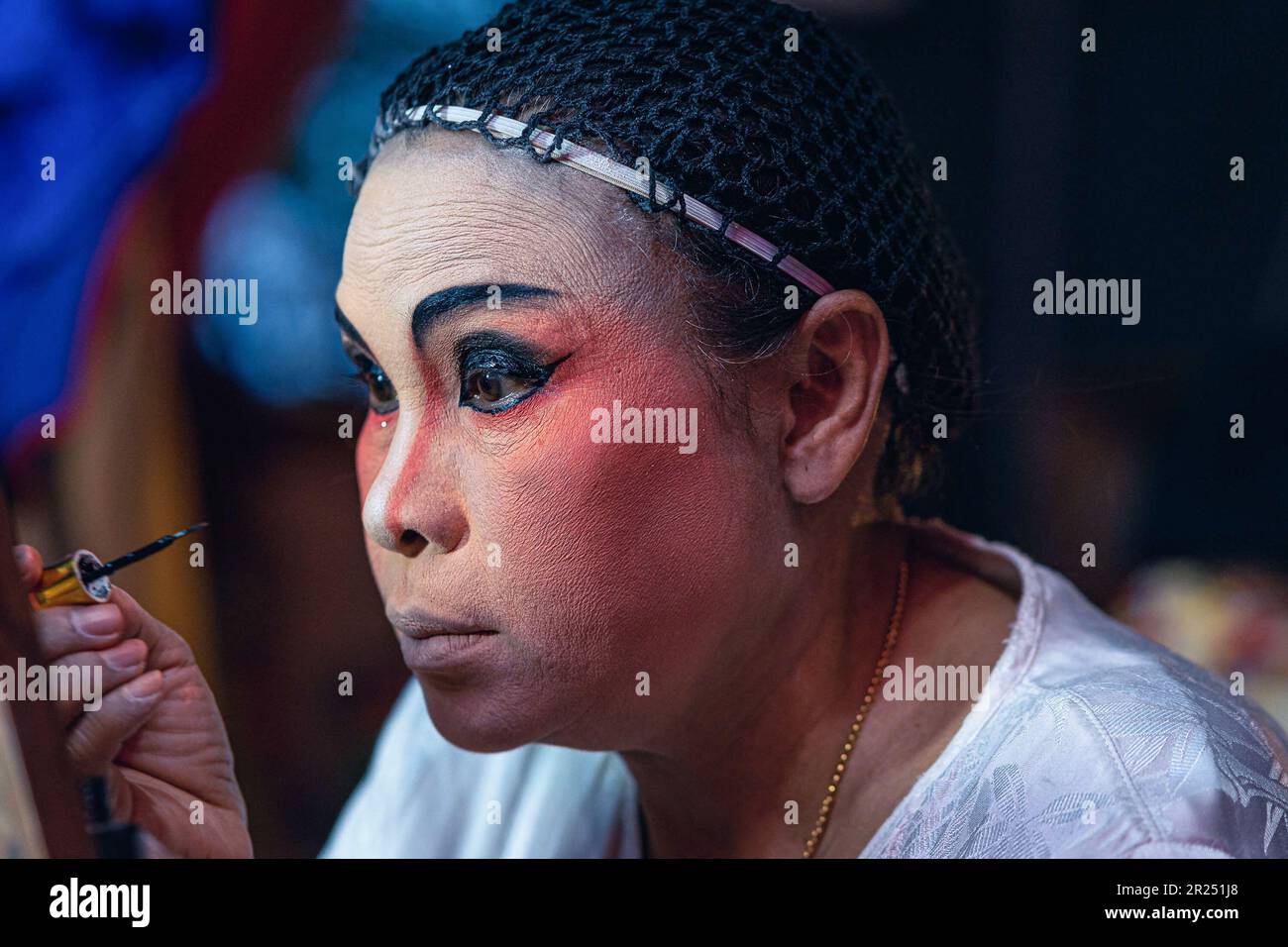 Bangkok, Thailandia. 16th maggio, 2023. Il performer dell'opera cinese prepara il make-up per uno spettacolo in un tempio di Bangkok. Artista lirico cinese della troupe e Lai Heng Giah Tuang visto prima della loro esecuzione in un tempio di Bangkok. Nel 19th ° secolo l'opera teo Chew era la forma di intrattenimento più popolare della città con centinaia di troupe che si esibivano a grandi folle; oggi il suo fascino sta diminuendo con meno di 20 troupe che si esibiscono a folle sempre più sparse. Credit: SOPA Images Limited/Alamy Live News Foto Stock