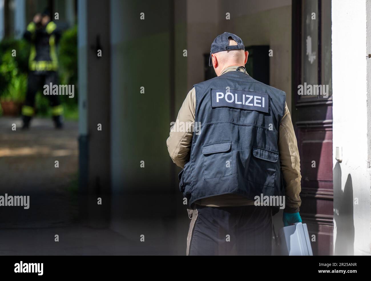 17 maggio 2023, Sassonia, Chemnitz: Un agente forense della polizia attraversa l'ingresso di un edificio di appartamenti a Kanalstraße, nel quartiere Schlossschemnitz. Durante un'operazione di polizia a Chemnitz, un uomo è stato ferito da colpi di polizia. Secondo la polizia, il 31 aveva in precedenza puntato sugli ufficiali con una balestra mercoledì. Una pallottola aveva colpito uno scudo di polizia. Dopo di che, il 31-year-old ha continuato a puntare l'arma contro gli ufficiali di polizia. Gli ufficiali poi raggiunsero per le loro armi di servizio e spararono diversi colpi. Il 31-year-old è stato colpito. È stato portato in ospedale. La polizia offi Foto Stock