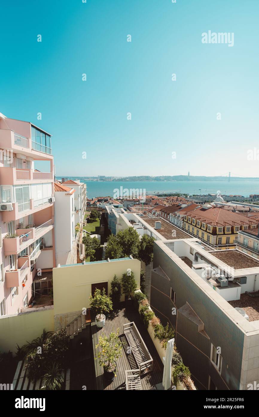 Lisbona; verticale; grandangolo; vista da un appartamento con una facciata color salmone alla città, che mostra il fiume Tejo e la replica del Golden Foto Stock