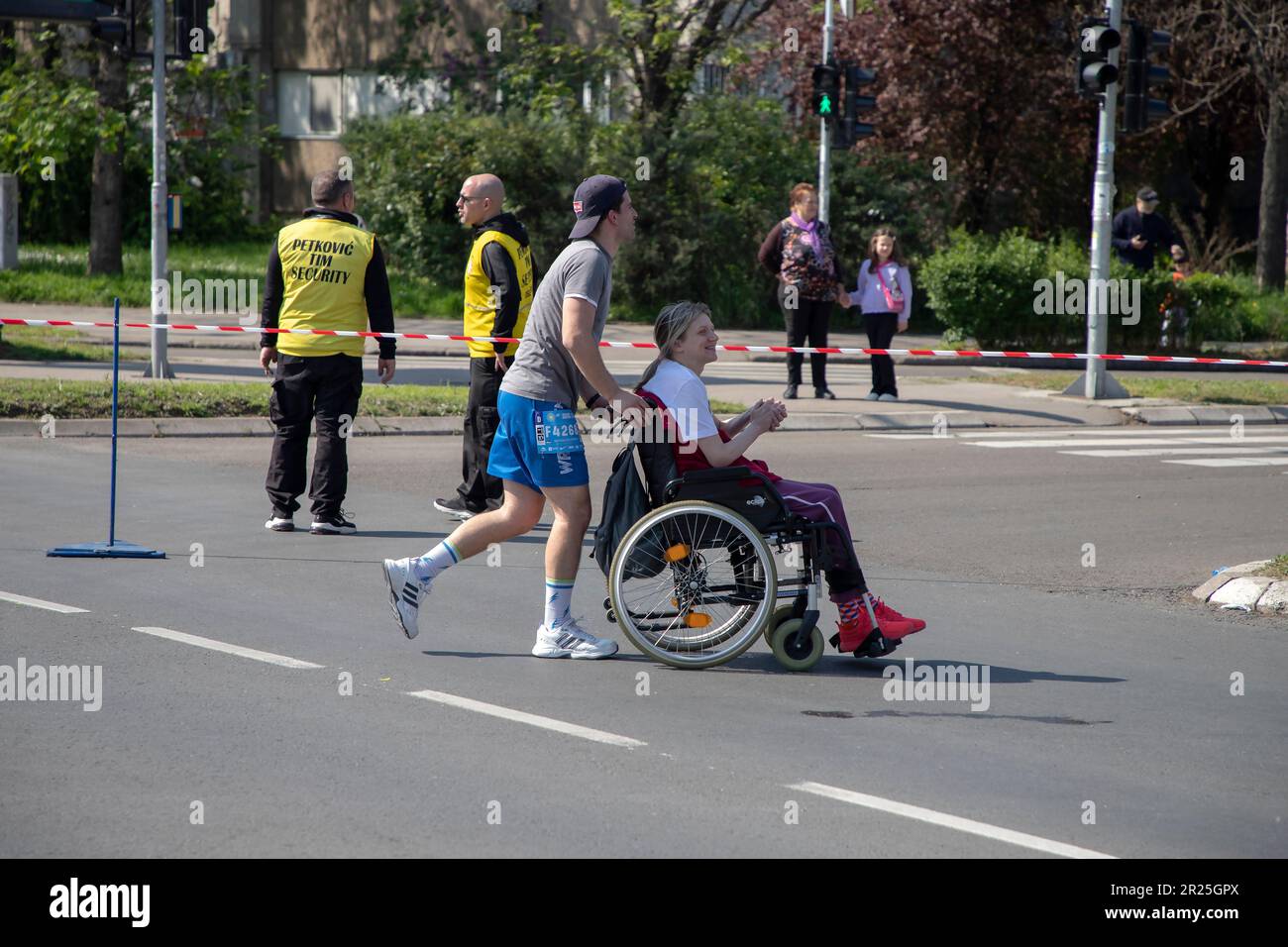 Belgrado, Serbia, 23 aprile 2023: Un uomo che spinge una sedia a rotelle partecipa a una gara di maratona Foto Stock