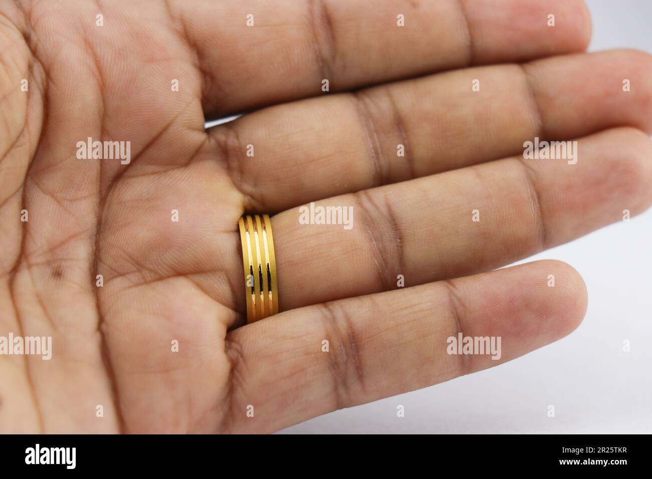Anello d'oro indossato sul dito. Anello di nozze d'oro indossato sul dito anello Foto Stock