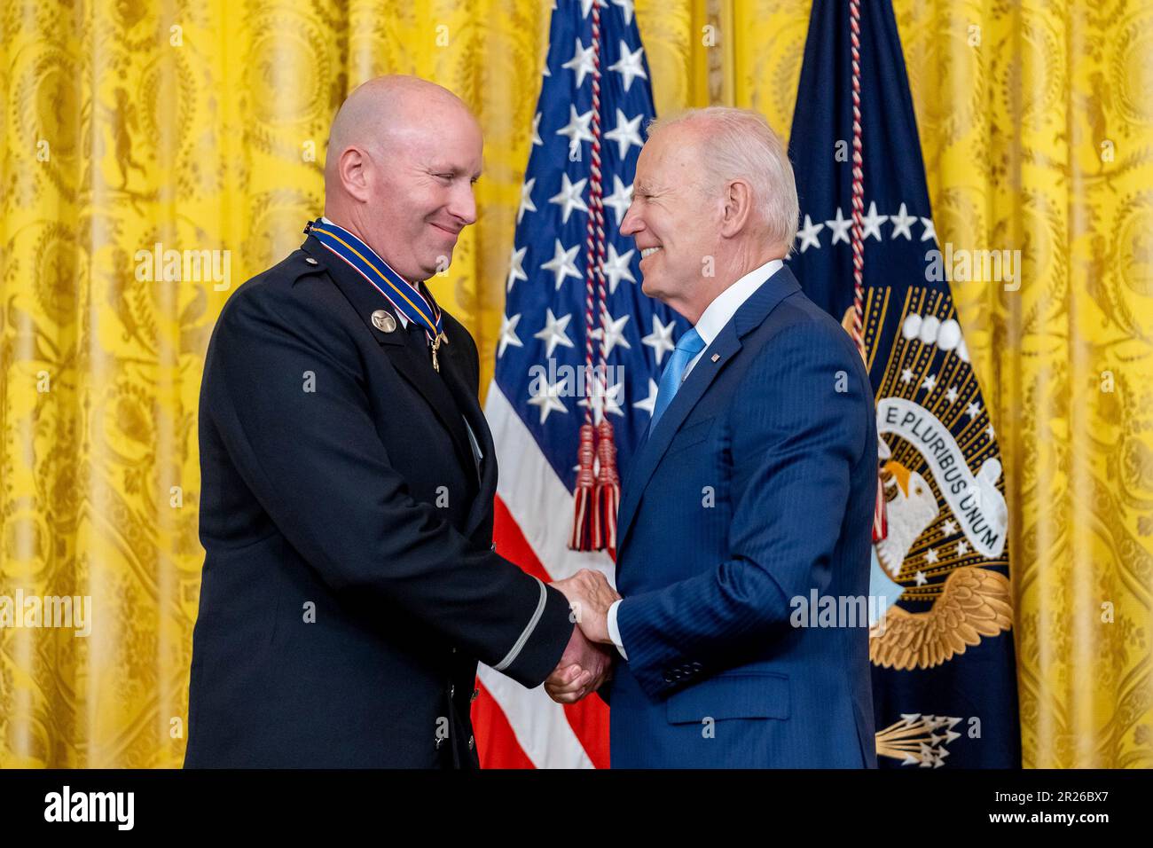 Washington, Stati Uniti d'America. 17th maggio, 2023. Washington, Stati Uniti d'America. 17 maggio, 2023. Il presidente degli Stati Uniti Joe Biden, a destra, si congratula con il vigile del fuoco di New York Patrick Thornton con la Medal of Valor, responsabile della pubblica sicurezza, durante una cerimonia nella Sala Est della Casa Bianca, il 17 maggio 2023 a Washington, DC la medaglia è la decorazione più alta delle nazioni per un ufficiale di pubblica sicurezza per gli atti di coraggio. Credit: Adam Schultz/White House Photo/Alamy Live News Foto Stock